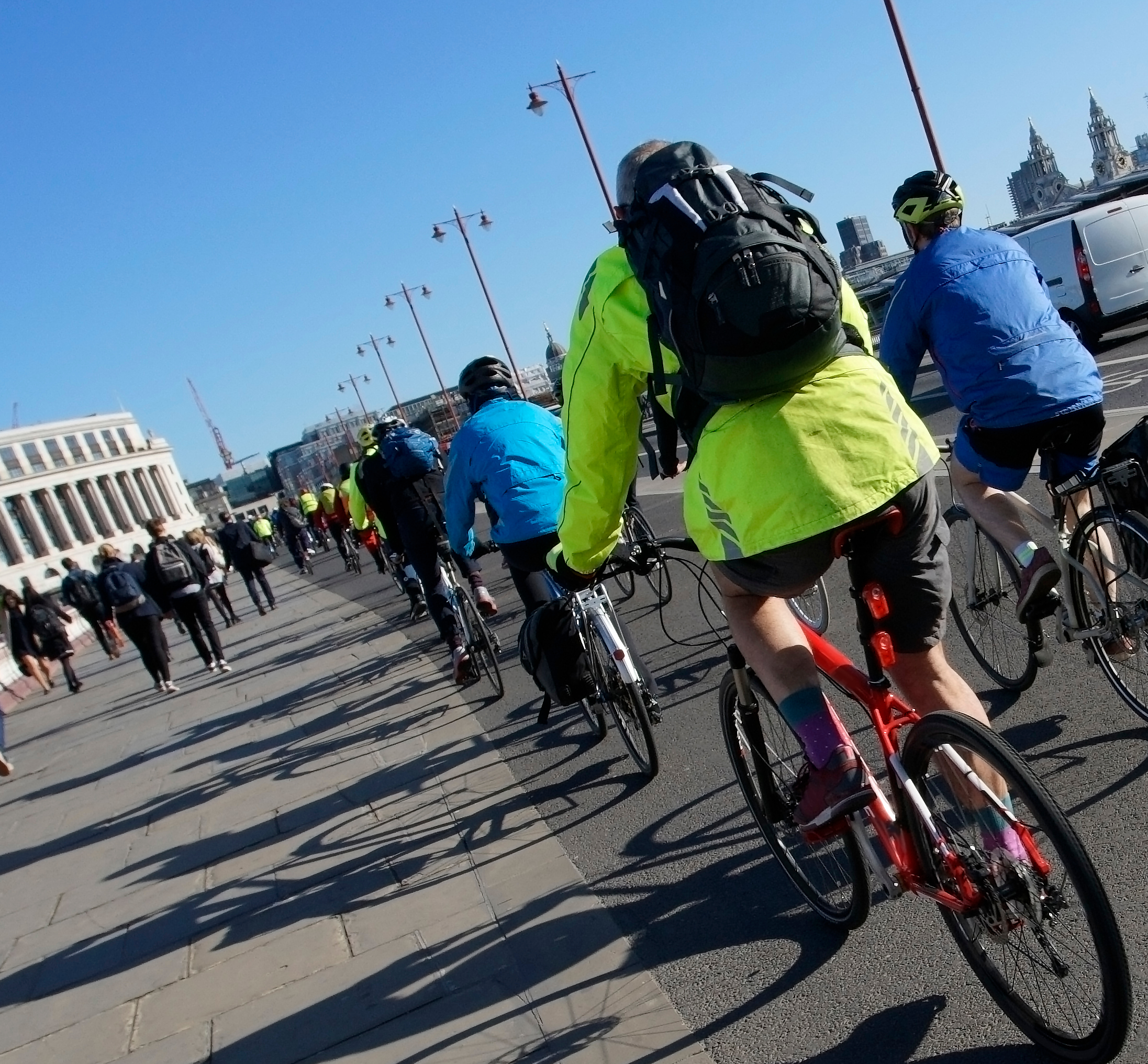 Photo from the back of a group of cyclists cycling in a bike lane