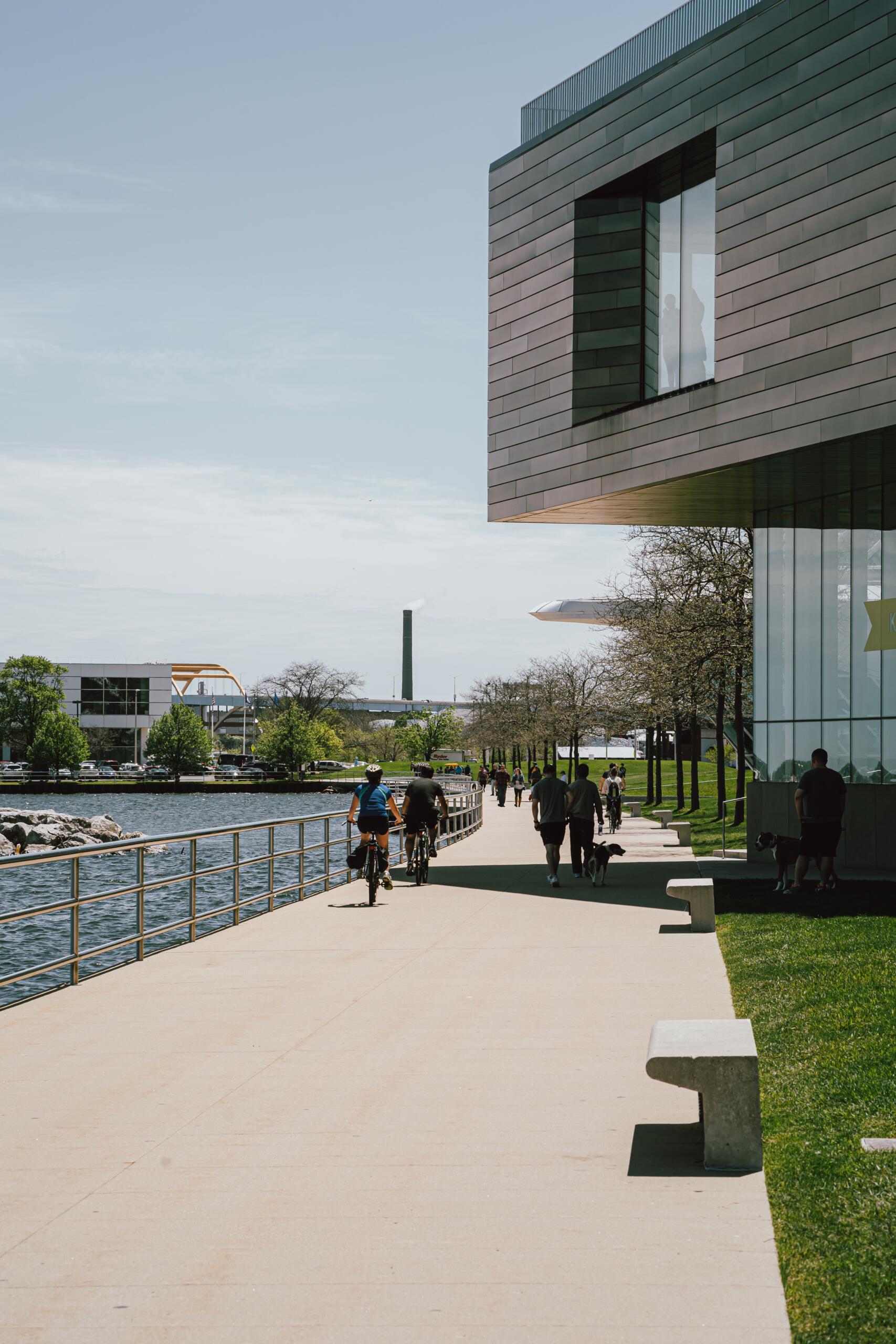 Photo of a bike lane along a river with people walking and biking