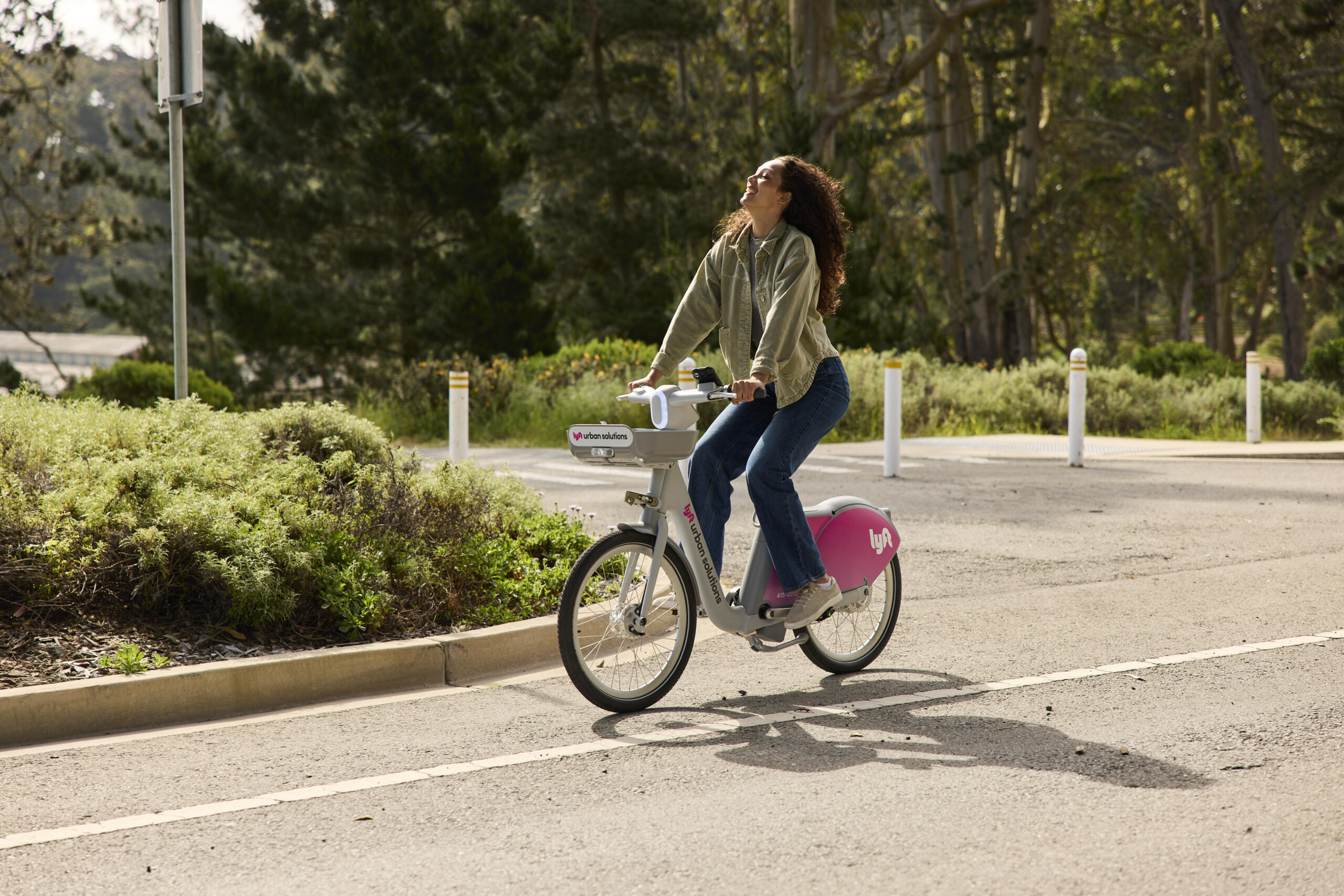 Photo of a woman cycling with a Lyft shared bike in a street