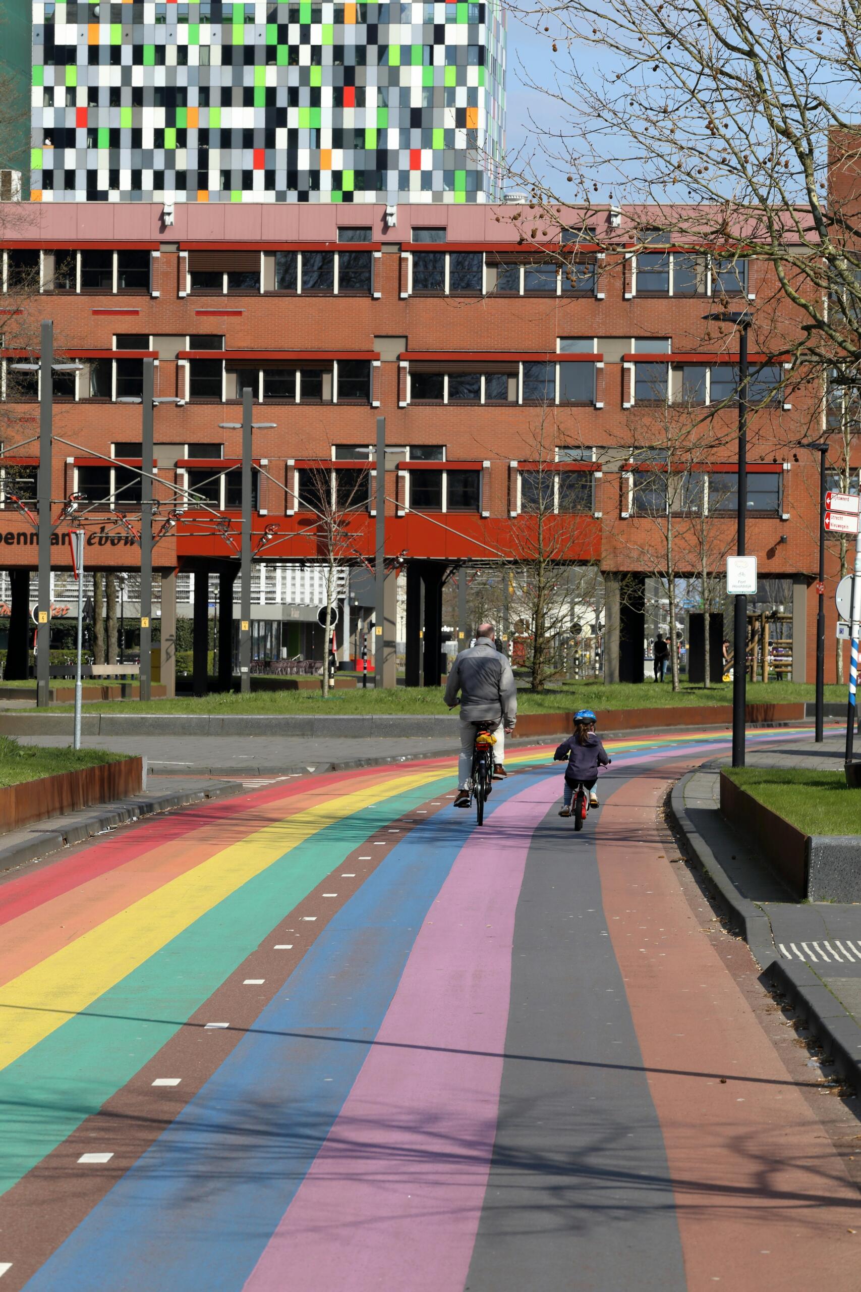 Father and child cyclingon rainbow bike lane in Utrecht