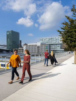 Two women walking on an elevated sidewalk in Utrecht