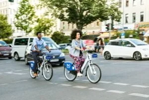 man and woman riding bicycle on road during daytime