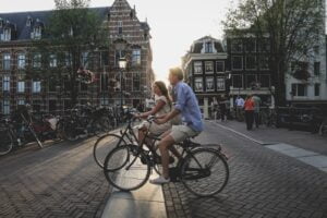 man and woman biking along city at daytime