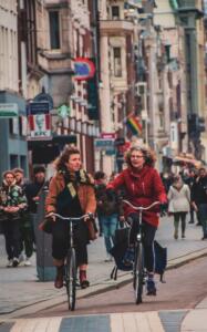 man in red long sleeve shirt riding bicycle on street during daytime